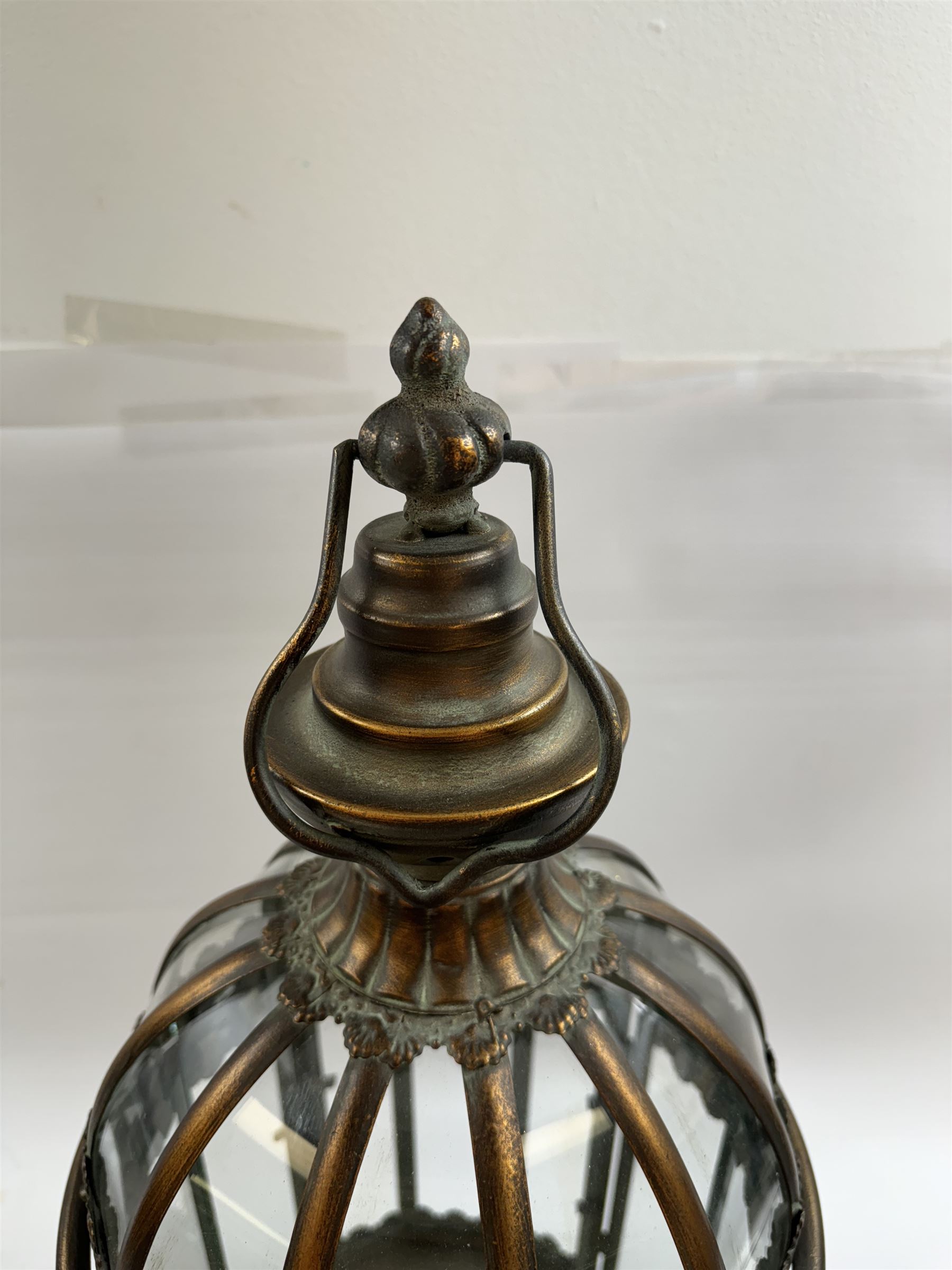 Pair of patinated brushed brass lanterns, of domed hexagonal form, with pierced gallery and swing handle, H63cm 


