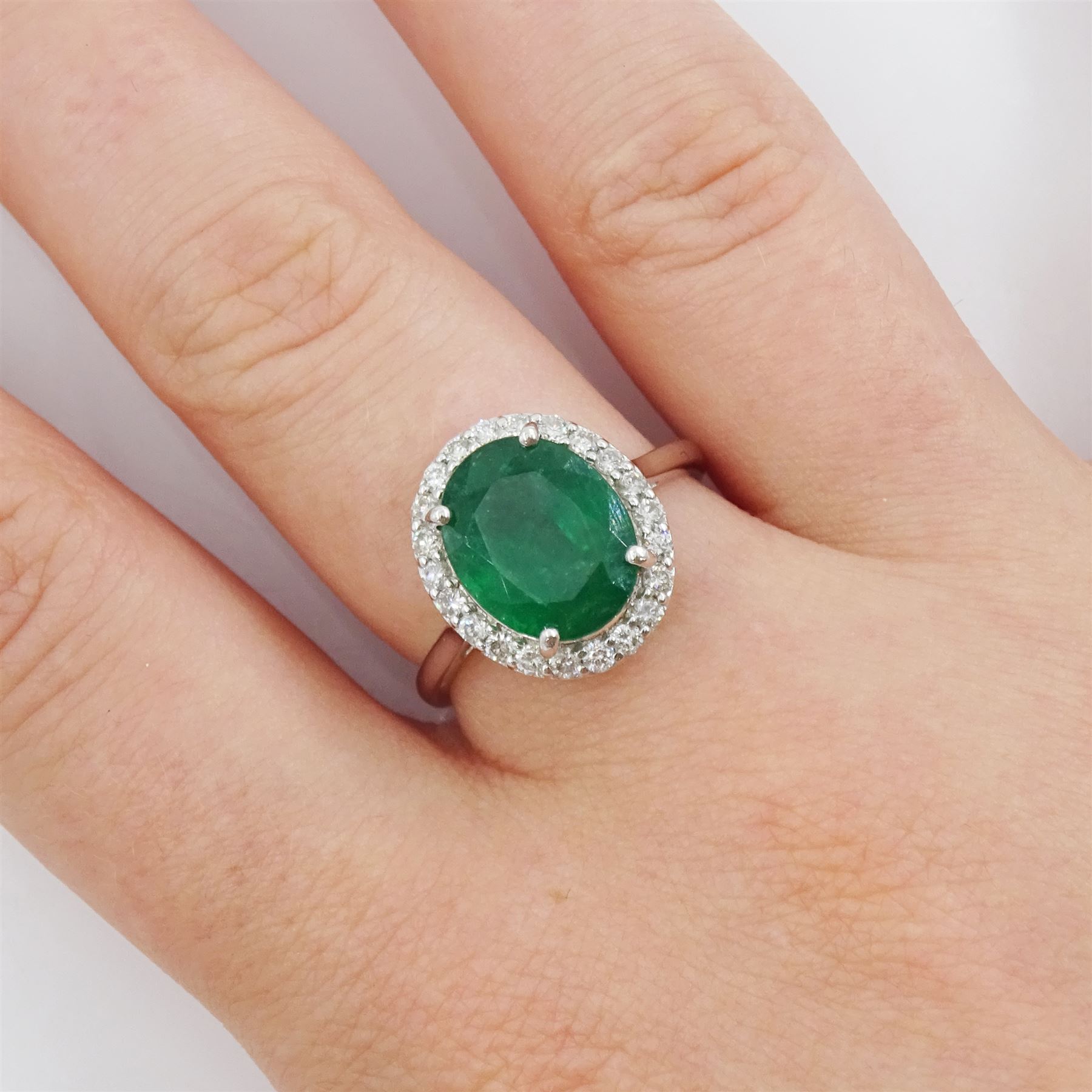 18ct white gold oval cut emerald and round brilliant cut diamond cluster ring, hallmarked, total emerald weight 3.33 carat, total diamond weight 0.40 carat, with World Gemological Institute Report