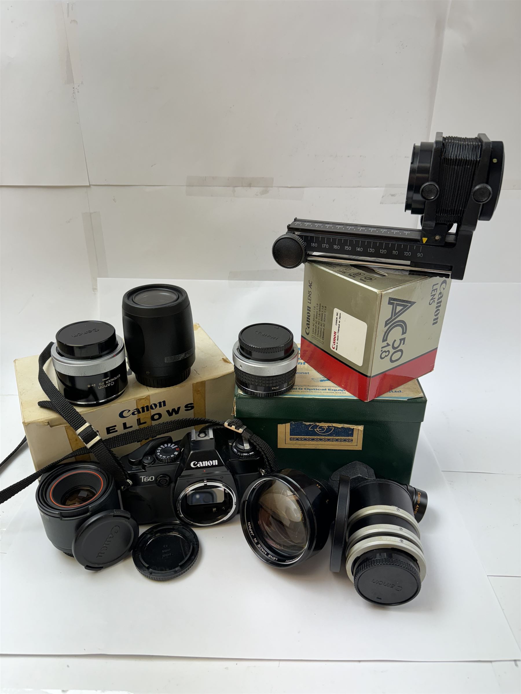 Canon T60 camera body serial no 25230455 together with a collection of Canon camera accessories, including zoom lenses, bellows, etc 