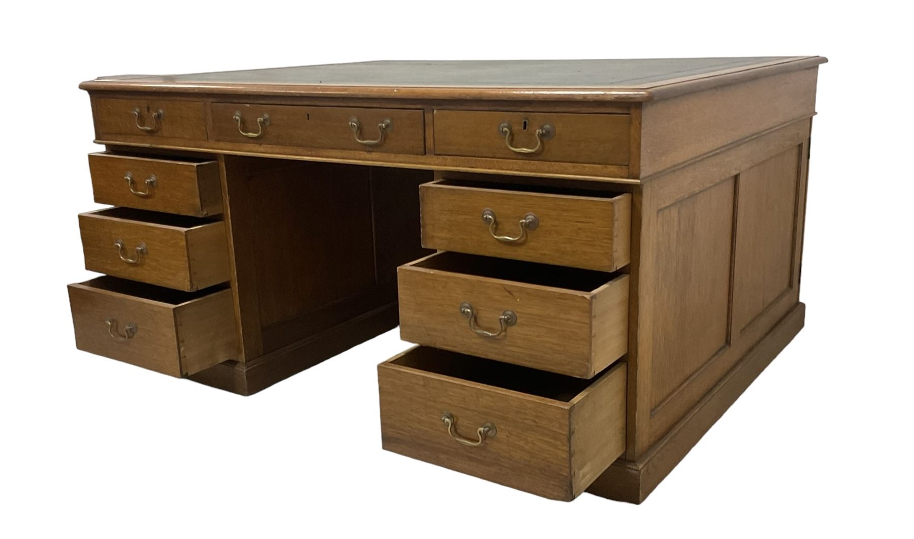 Late 19th century twin pedestal oak partner's desk, rectangular top with inset green leather writing surface, fitted with nine graduating drawers to each side, the rear drawers enclosed by panelled cupboards