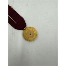 9ct gold Masonic jewel, the circular medal decorated with a stone set crown within a triangle, inscribed 'Redcar Chapter No 1244', suspending from a burgundy ribbon with applied enamel reading 'Quinguagesimus Secundus M.E.Z 1970-71', presented to 'E Comp A.P. Clark' hallmarked to pin and medallion, L11.5cm