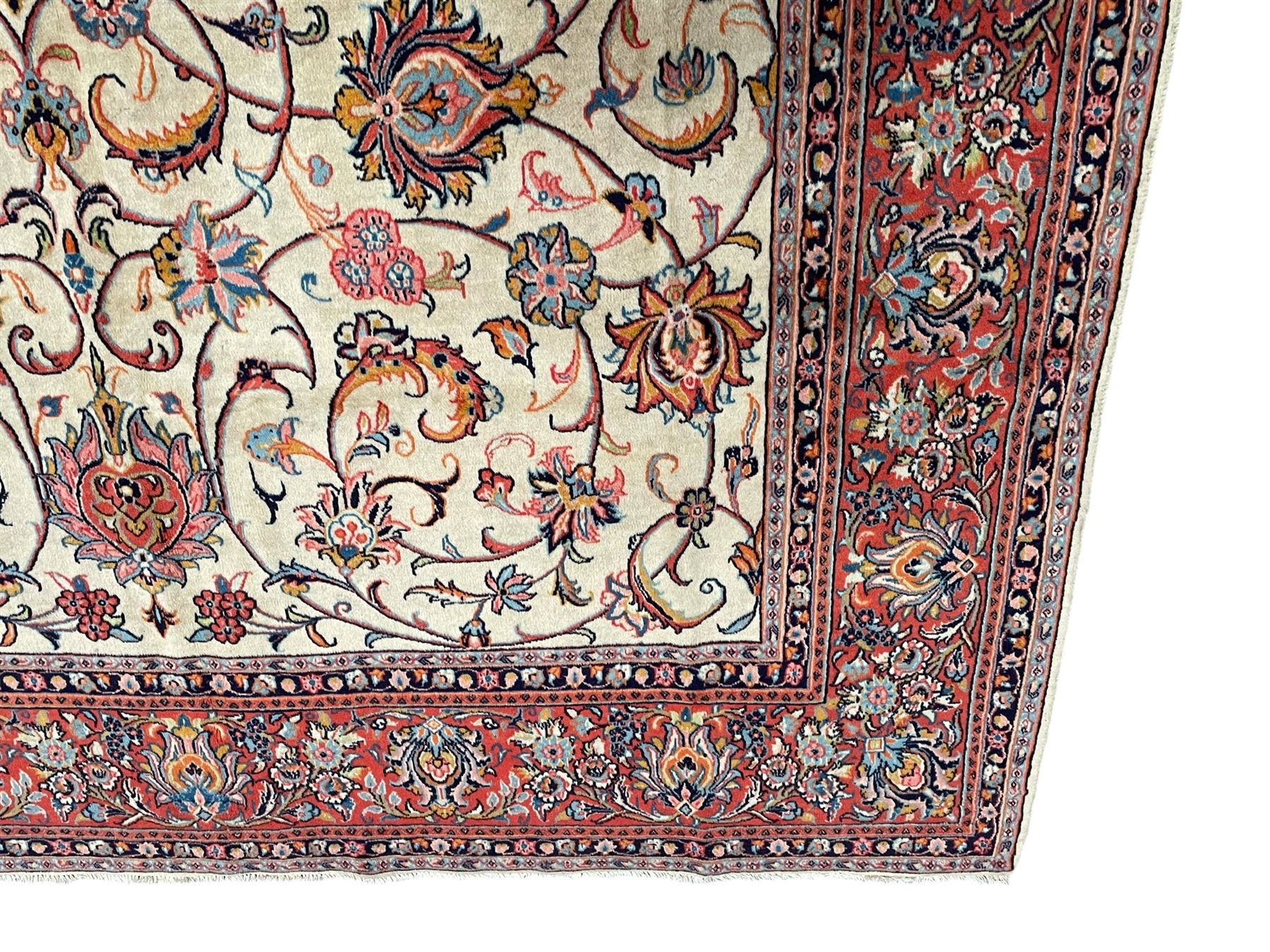 Persian Sarough ivory ground rug, the field decorated with curled leafy branches and palmettes, crimson ground border decorated with further palmettes and floral sprays, within guard stripes 