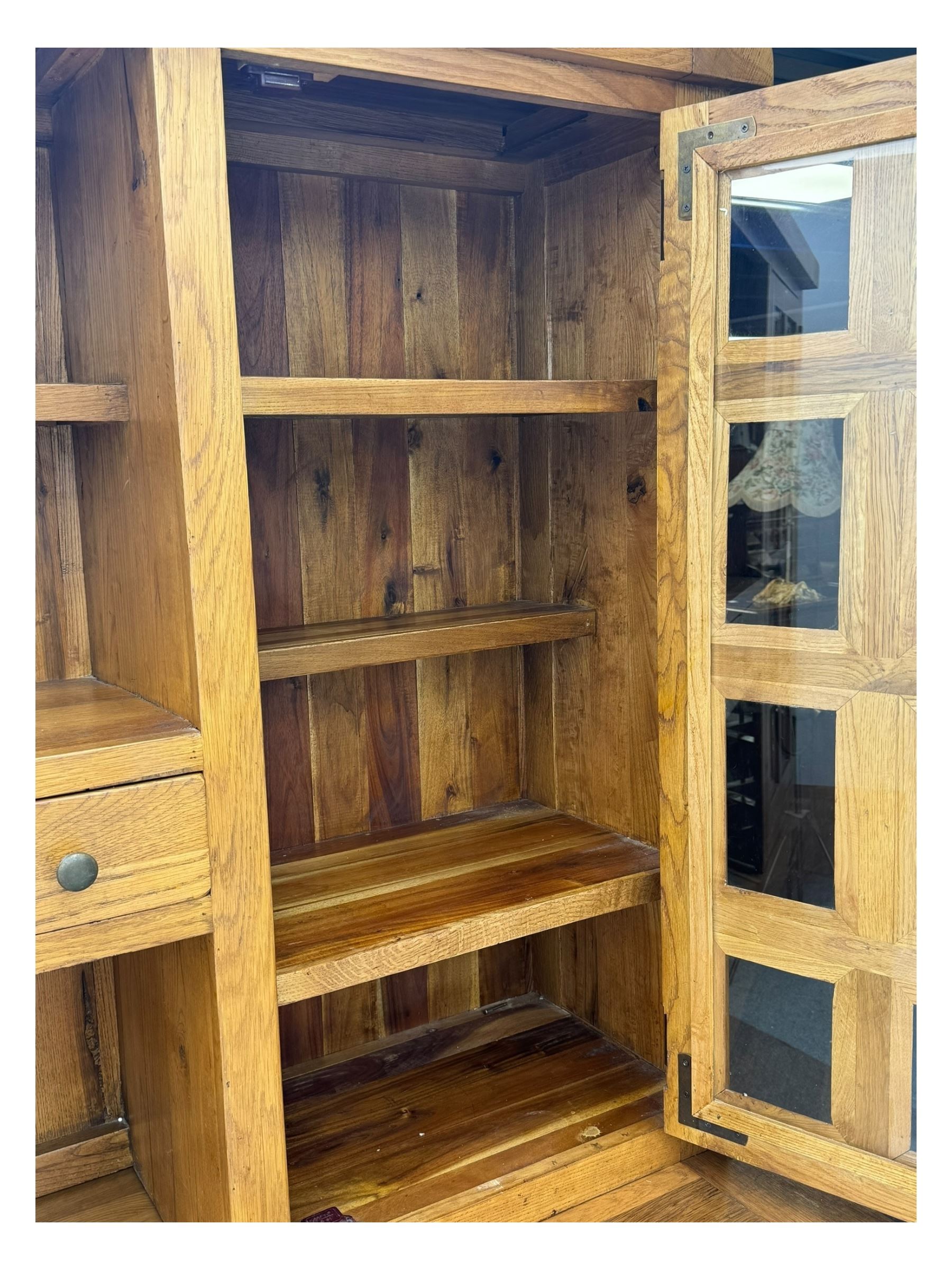 Oak dresser, upper section with twin glazed cupboard doors and central shelving with two trinket drawers, lower section fitted with six drawers over three panelled cupboard doors, raised on shaped feet 