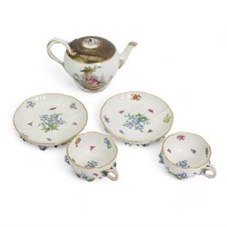 Pair of Meissen tea cups and saucers, encrusted with forget-me-nots and decorated with flowers and insects, raised on peg feet, H8cm and an early 20th century Meissen teapot, decorated with courting couples, H12cm (3)