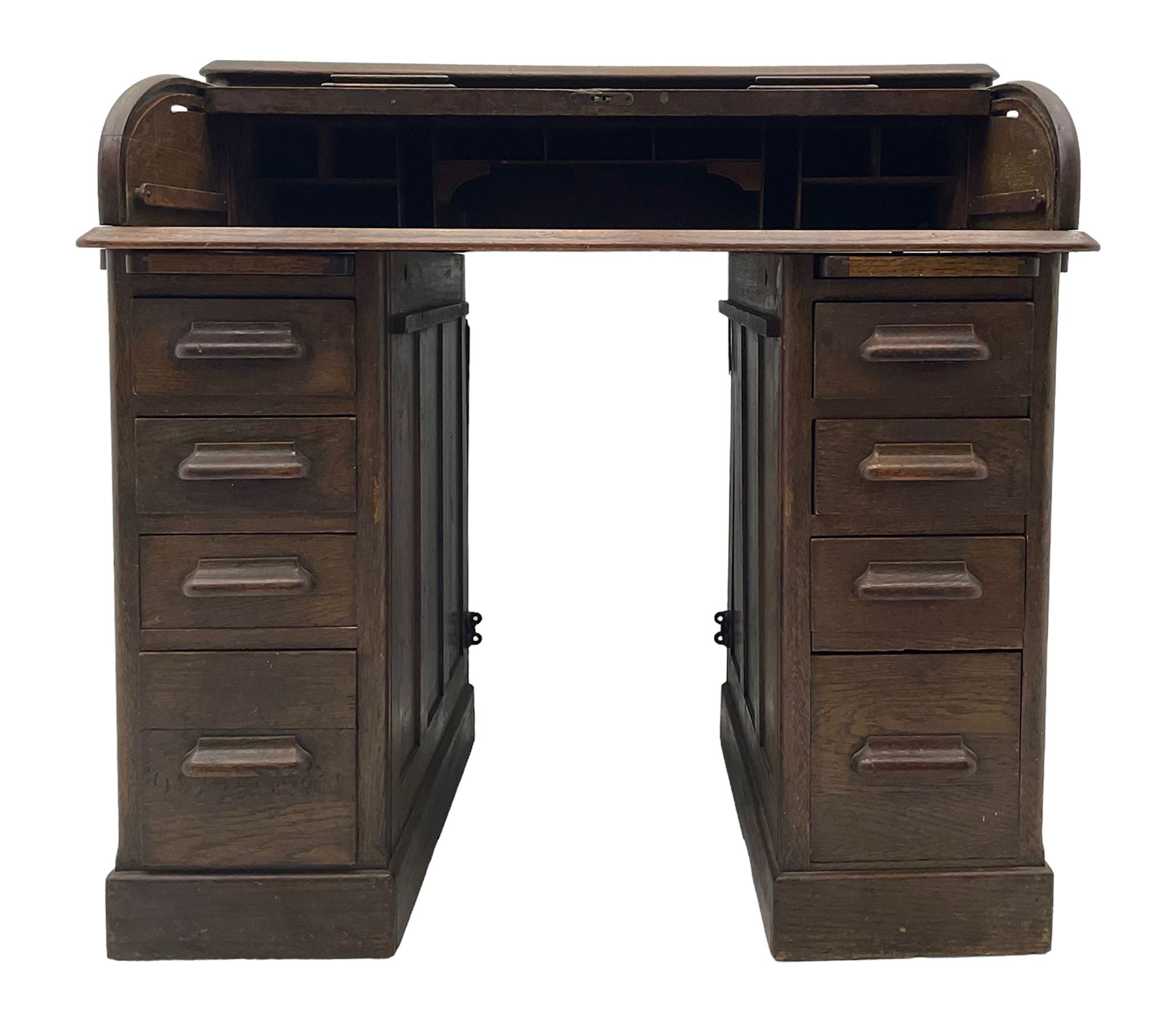 Early 20th century oak twin pedestal roll top desk, tambour roll enclosing fitted interior, each pedestal fitted with four drawers and slide, on plinth base 