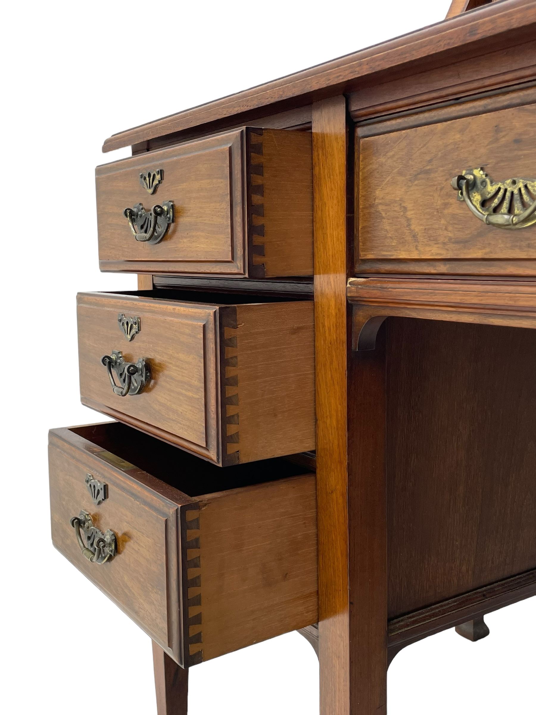 Late 19th century walnut dressing table, wide rectangular bevelled swing mirror in moulded frame, shaped horns carved with scrolls, moulded rectangular top over seven drawers, on square tapering supports with spade feet 