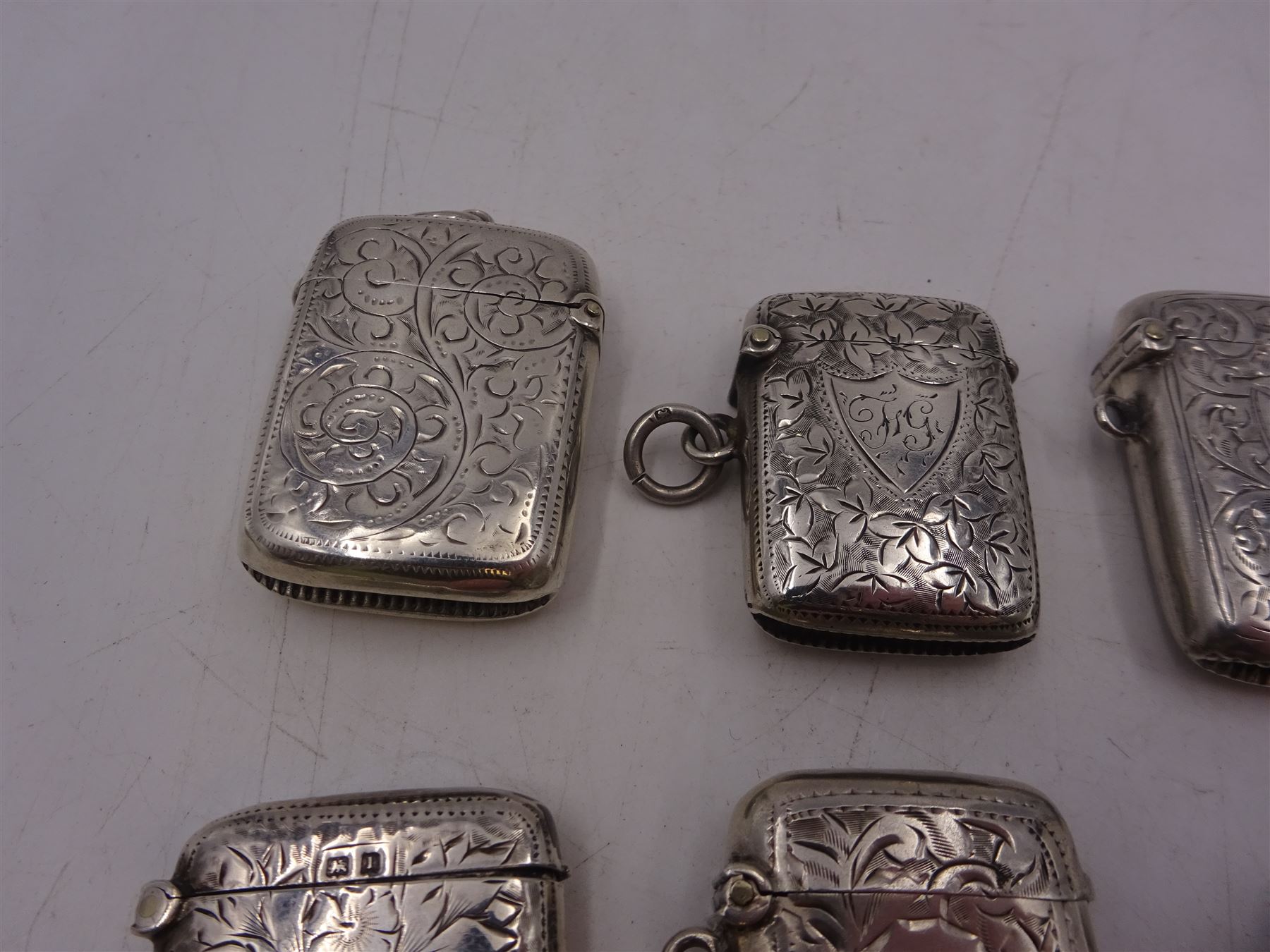 Seven early 20th century silver vesta cases, all of typical form, engraved with foliate and scrolling details, all hallmarked