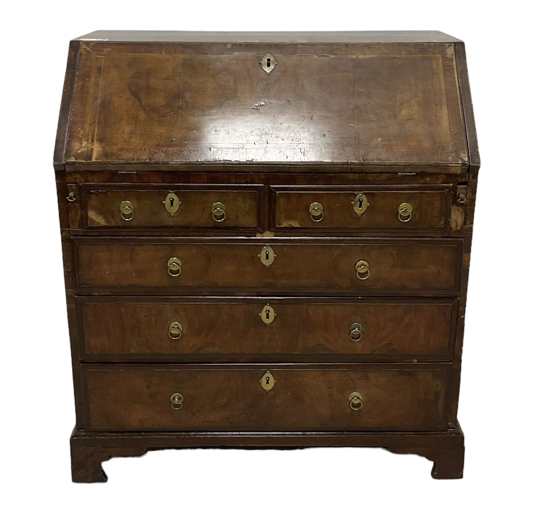 18th century walnut bureau, crossbanded and feather-banded rectangular top and fall-front, enclosing fitted interior with pigeonholes and correspondence drawers with bone handles, over two short and three long graduating drawers with moulded facias and original brass handles, on bracket feet