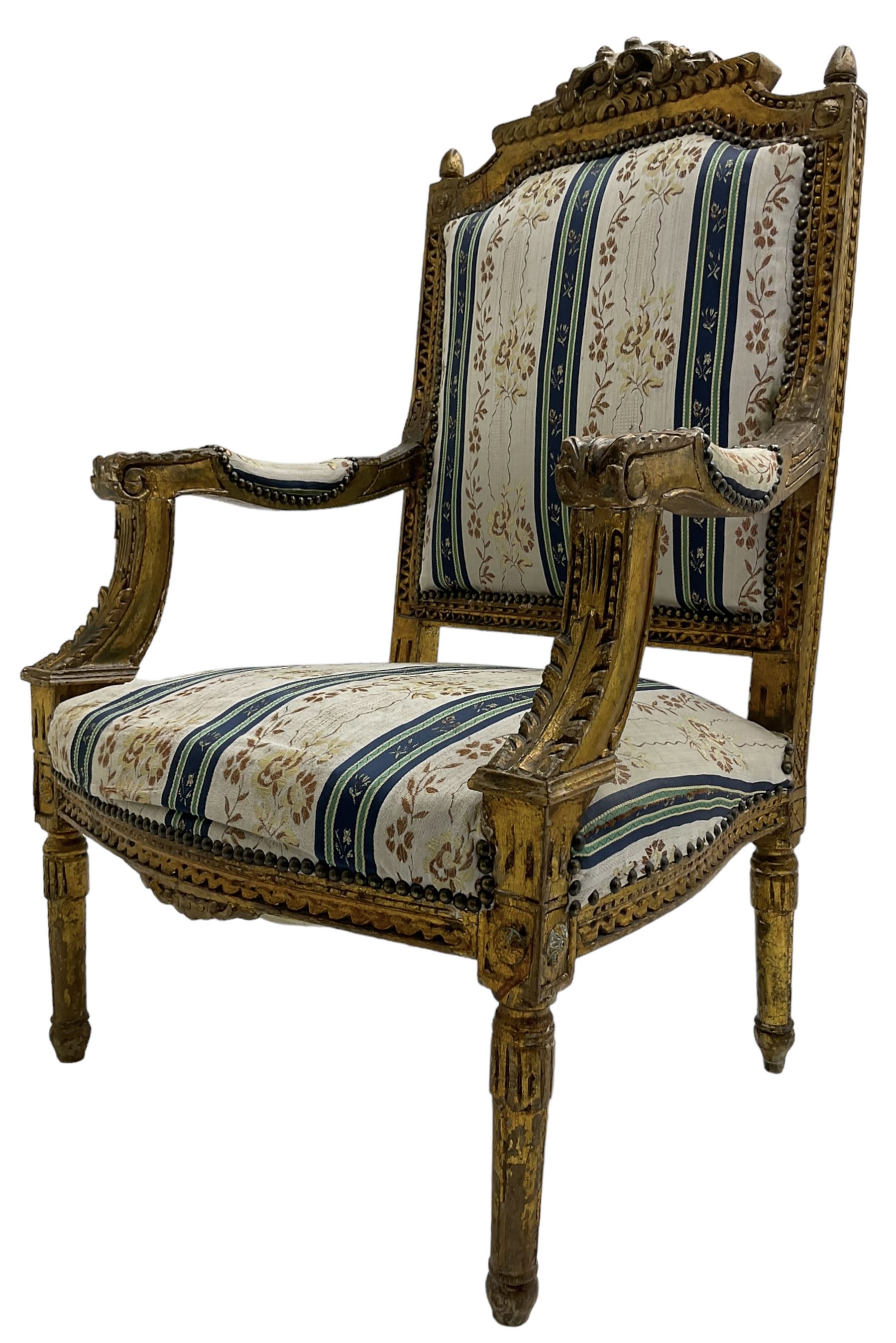 Late 20th century French design carved giltwood armchair, the cresting rail carved with scrolled foliage over foliate carved platform, upholstered in striped fabric decorated with trailing foliage and flower heads, acanthus carved arm terminals and upright supports, on turned and fluted supports 