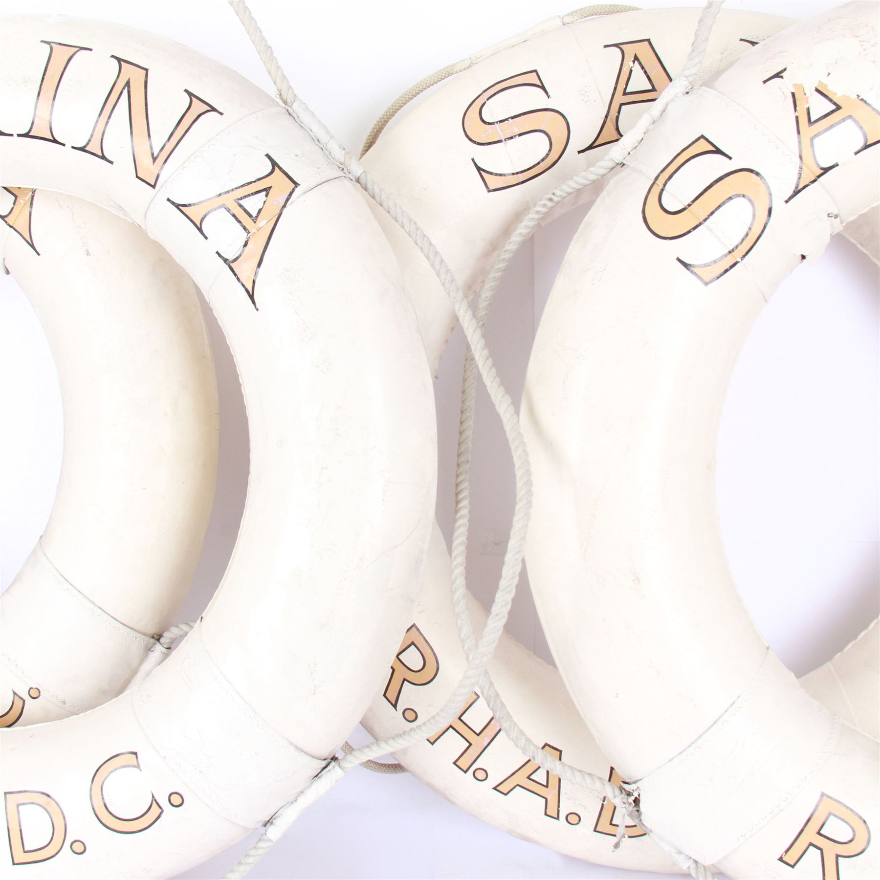 Four mid 20th century yacht lifebuoys, each painted in gold and black lettering 'Sarina R.H.A.D.C', upon a white ground, D68cm