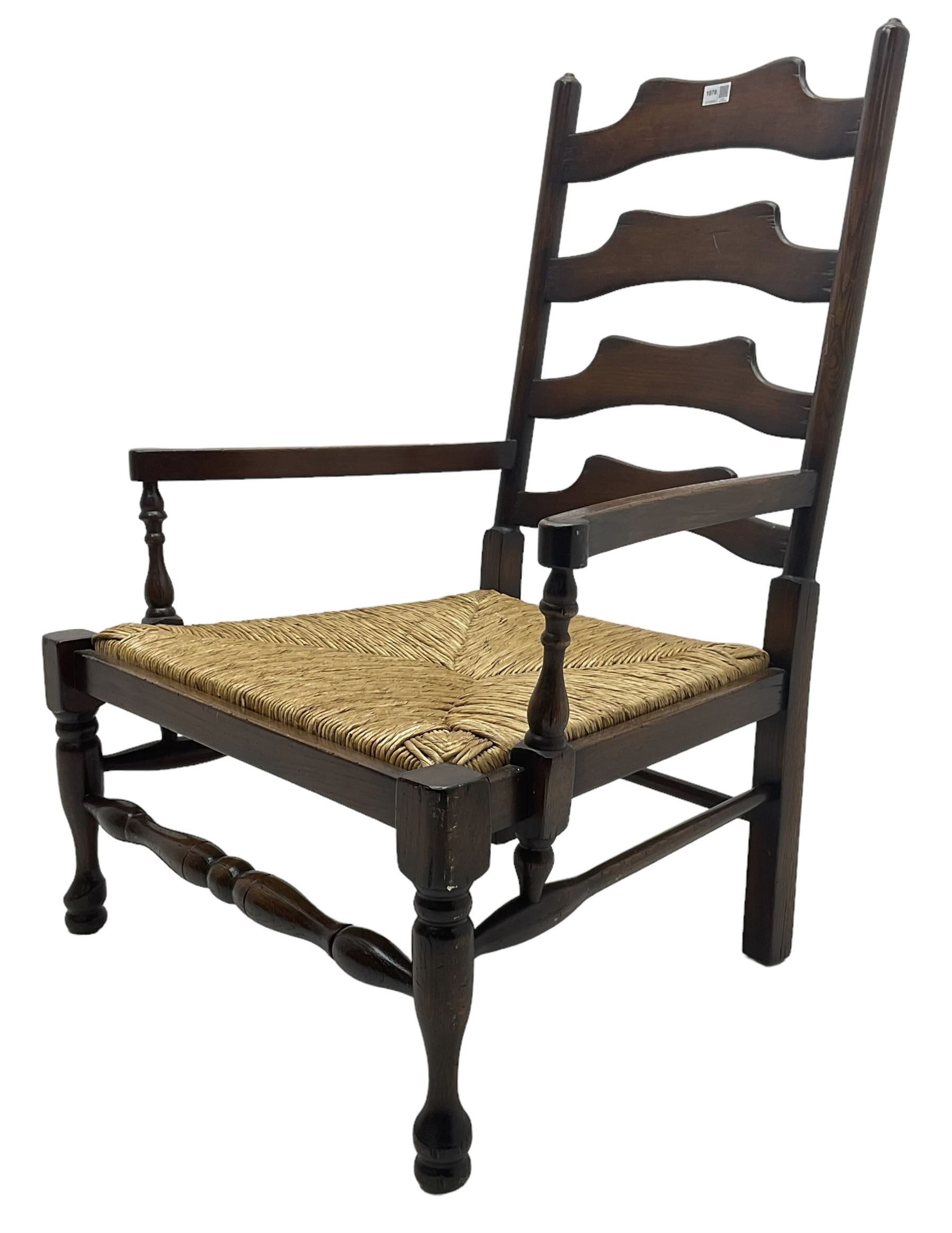 Georgian design oak country low armchair, waived ladder back over rush seat, raised on turned  supports united by stretchers; together with matching stool