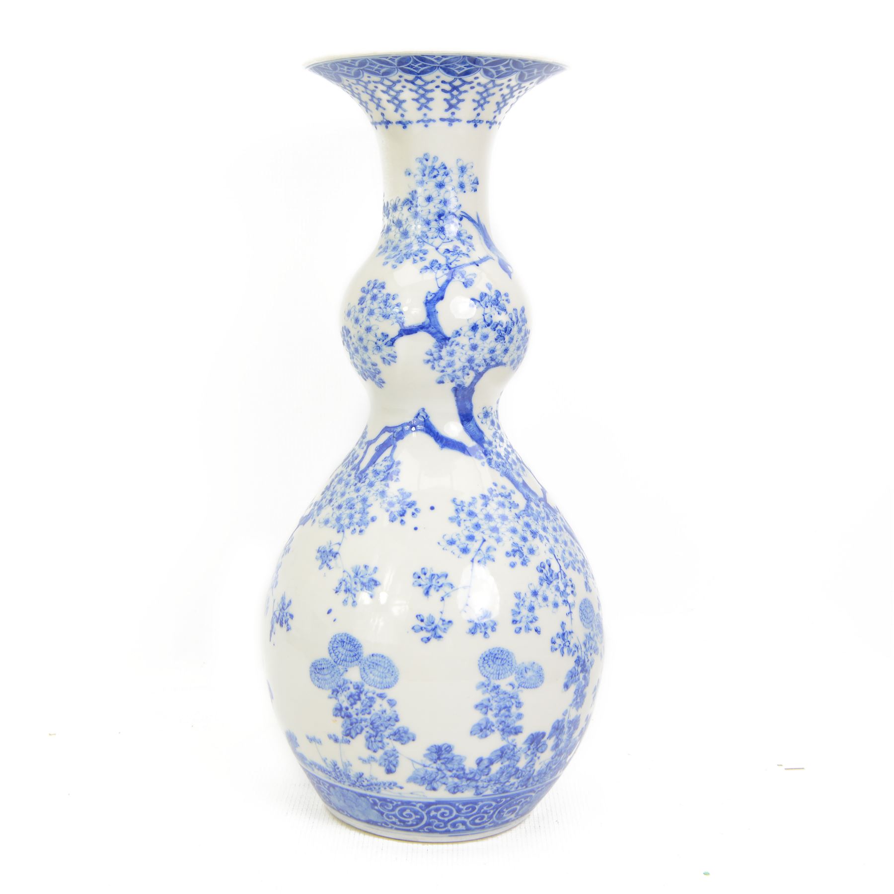 Japanese Meiji period porcelain double gourde vase, painted in blue with birds perched on a blossoming tree, within scroll and foliate borders, impressed seal mark beneath, H43.5cm 