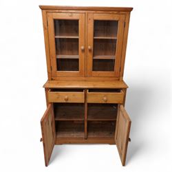 Late 20th century waxed pine dresser, raised display cabinet enclosed by two glazed doors, the base fitted with two drawers over panelled cupboard, on plinth base