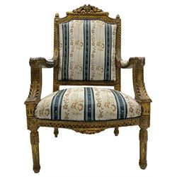 Late 20th century French design carved giltwood armchair, the cresting rail carved with scrolled foliage over foliate carved platform, upholstered in striped fabric decorated with trailing foliage and flower heads, acanthus carved arm terminals and upright supports, on turned and fluted supports 