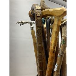 Oak barley twist stick stand, with a collection of walking sticks including examples with carved pommels, horn handles, silver collar etc, together with brass stick stand 