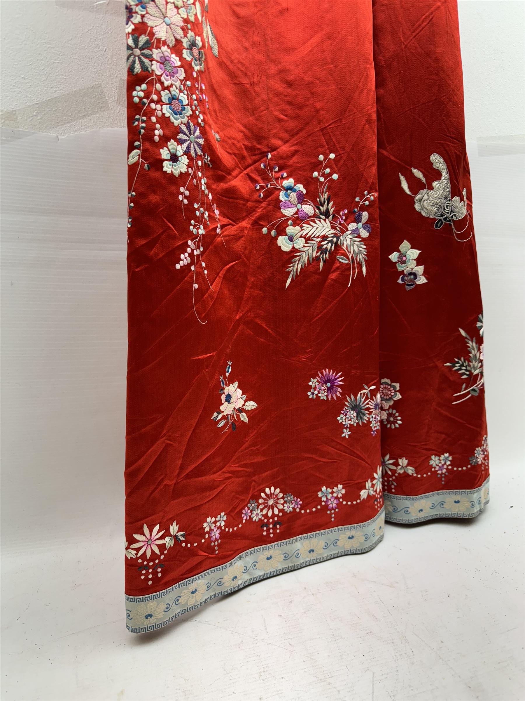 Early 20th century Chinese Han silk skirt, embroidered with flowers and butterflies, on a red ground, purchased from Liberty, London