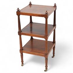 19th century mahogany three-tier what-not, rectangular top raised on ring-turned pilasters, terminating to brass castors