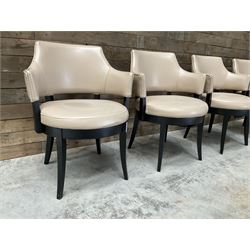 Four ebonised framed tub shaped armchairs, upholstered in beige fabric