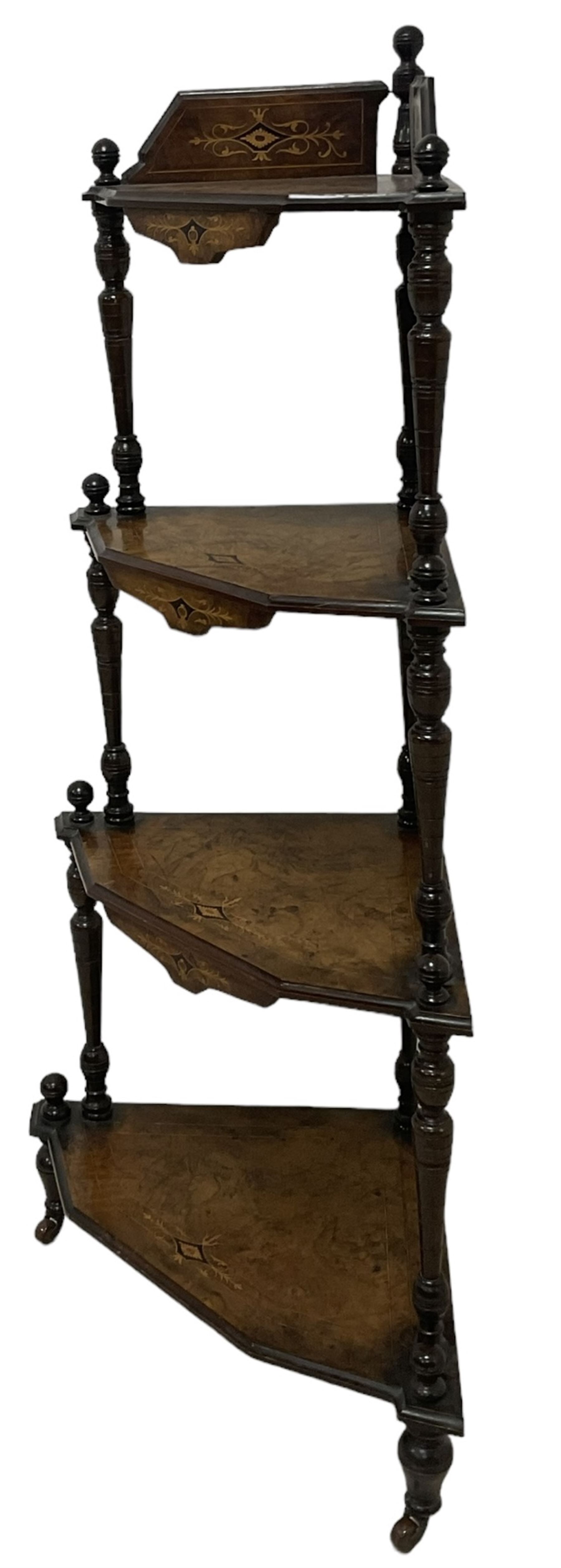 Victorian inlaid walnut corner four-tier whatnot, raised back over four graduating tiers of triangular form, decorated with satinwood and ebony inlays, united by tapering ring turned uprights, on castors