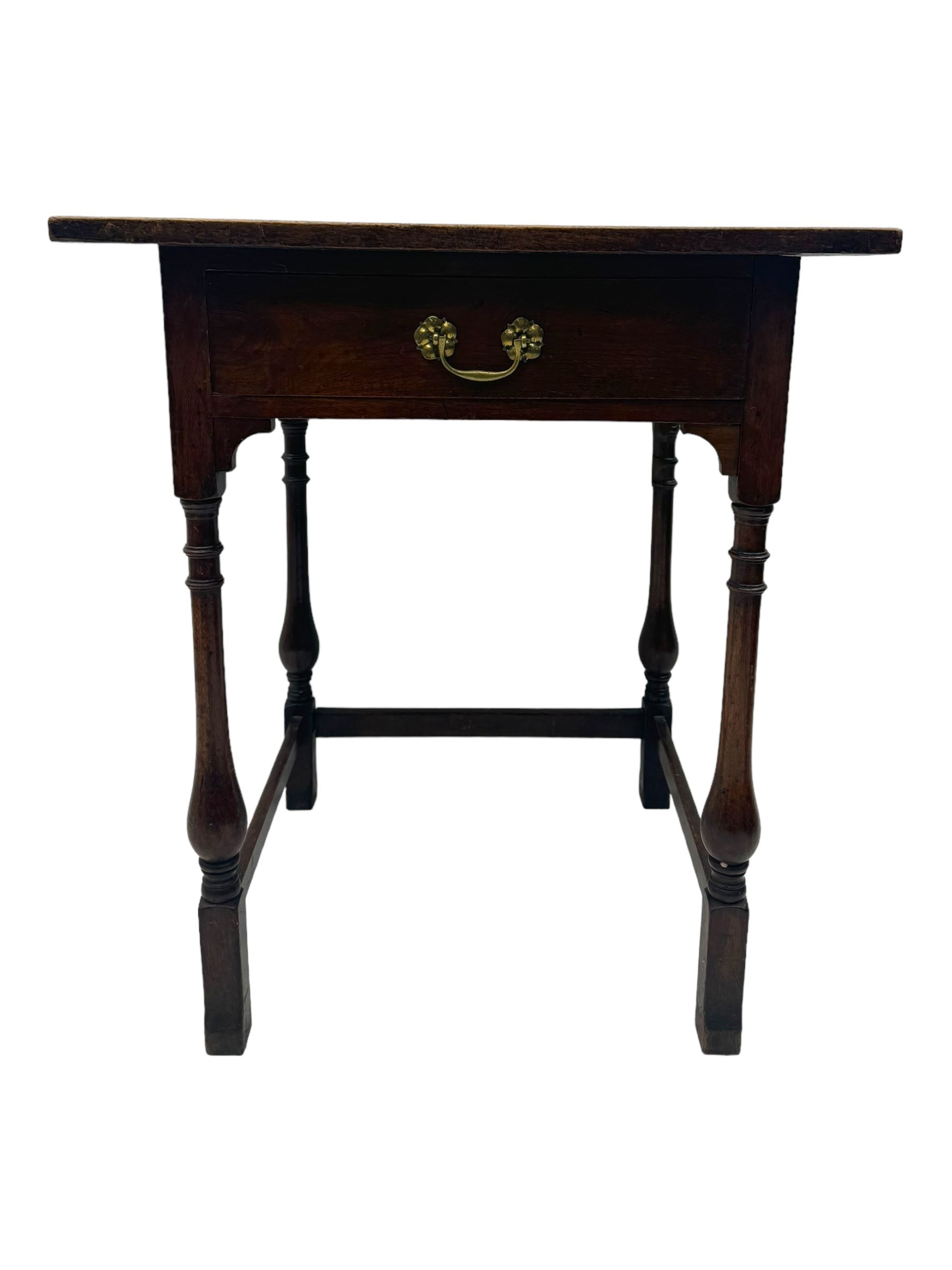 Early 20th century oak walnut lamp or side table, rectangular top with red leather insert, over single drawer with felt lining and brass handle, raised on turned supports with stretchers