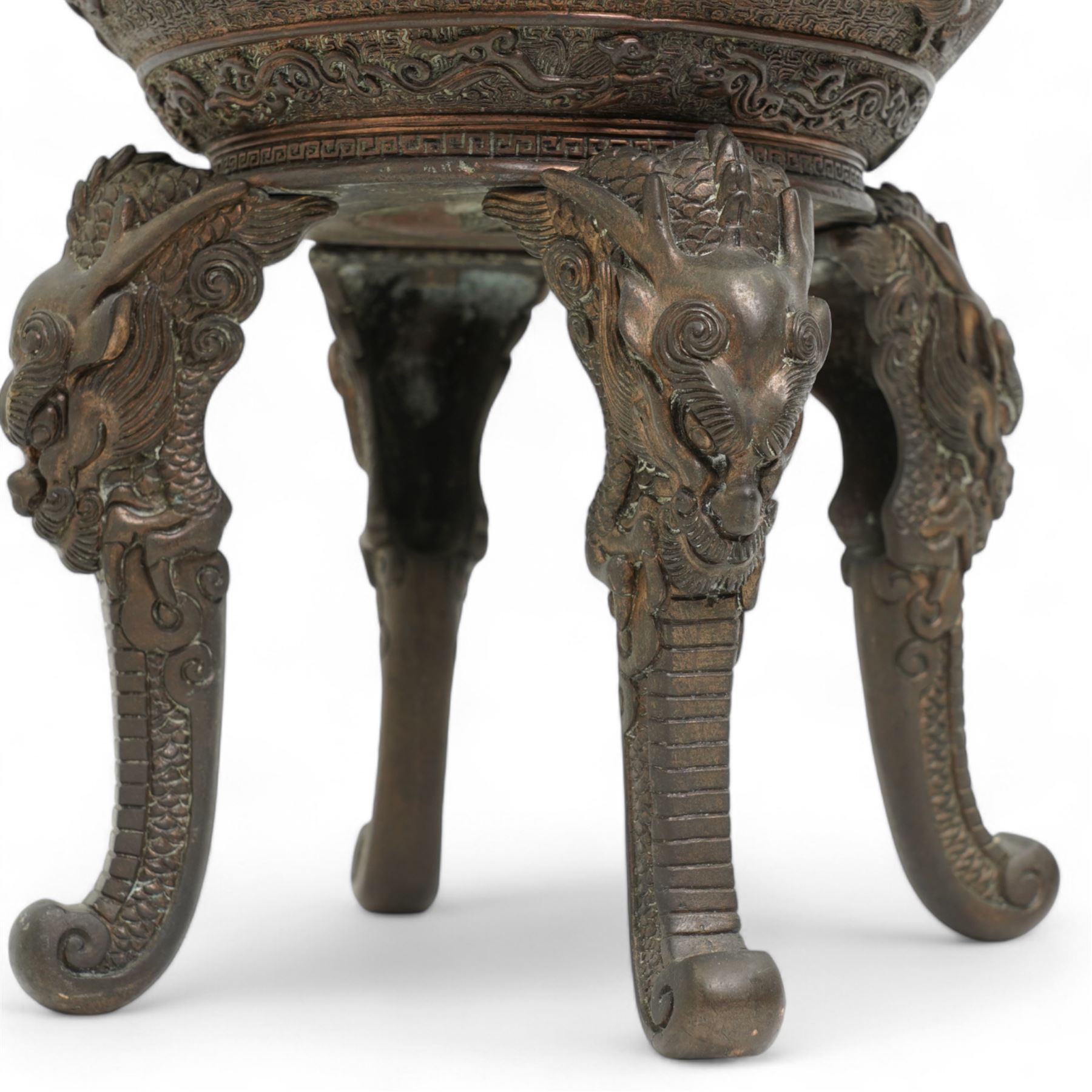 Large 19th century Japanese bronze koro, the ovoid body decorated in relief with phoenix and kylin amidst clouds, with two elongated loop handles and chrysanthemum finial, on four tall mask and tongue feet, impressed seal mark beneath, H44cm x W27cm 