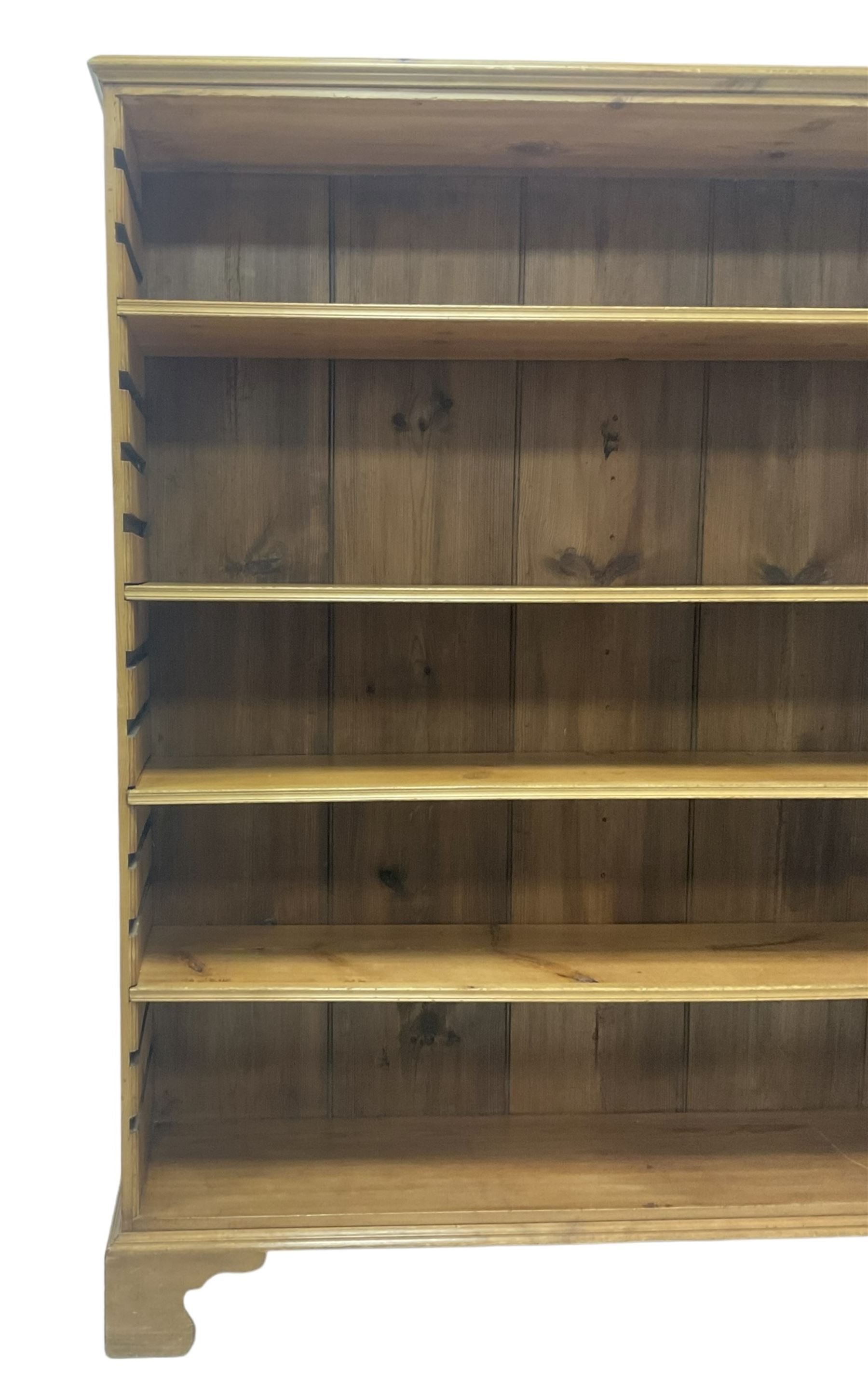 Georgian and later pine open bookcase, fitted with three adjustable shelves, on bracket feet