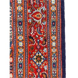 Persian Bidjar ivory and indigo ground rug, large central rosette medallion surrounded by floral herati motifs, crimson ground border decorated with repeating palmettes, within guard stripes decorated with small flower head motifs 