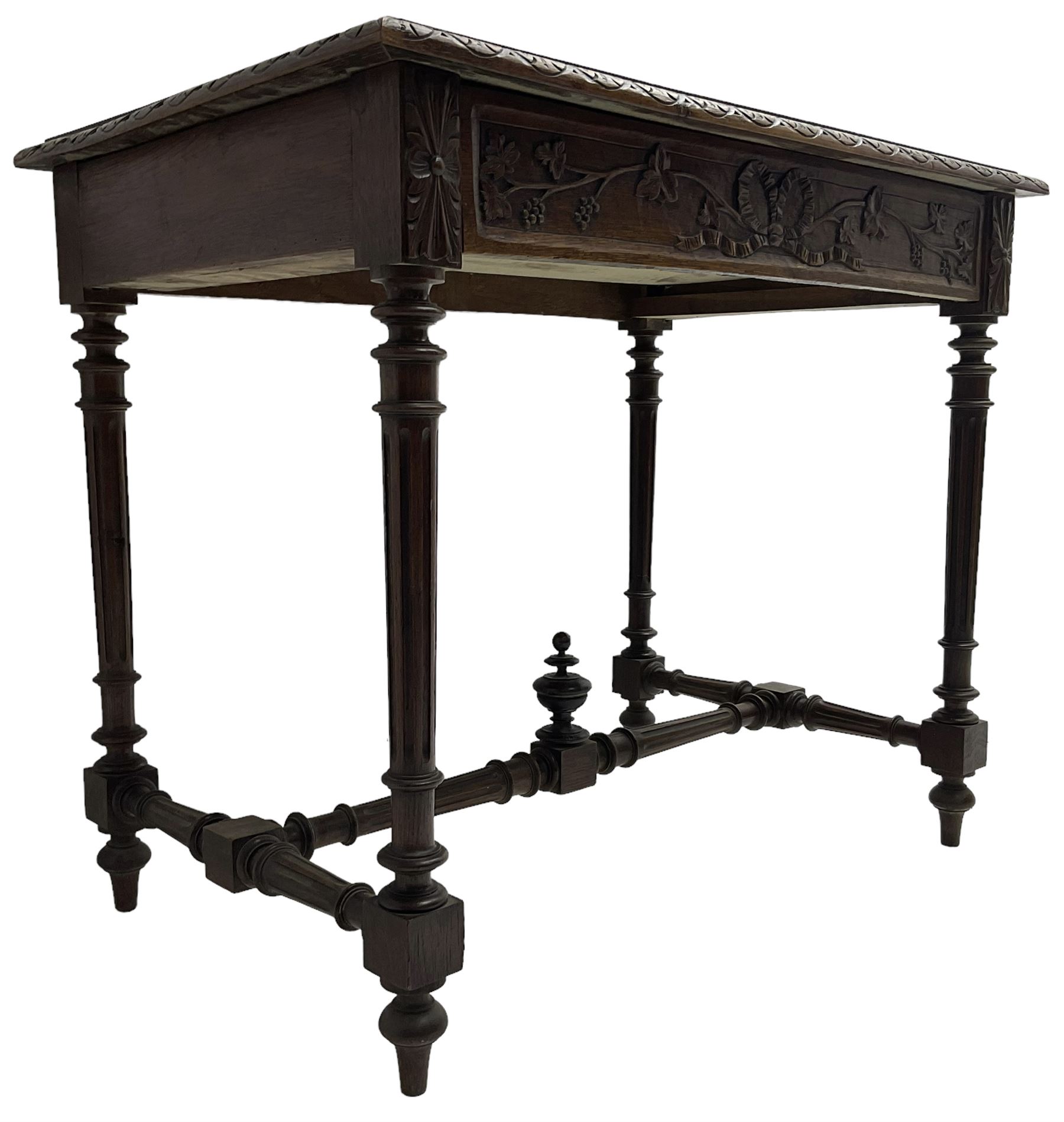 19th century walnut side table,  rectangular top with lunette carved moulded edge, the frieze drawer carved with ribbon and extending vine branch and grapes, on turned and fluted supports united by fluted stretcher with centre finial 