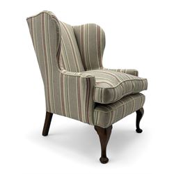 Georgian design hardwood-framed wingback armchair, curved wingback terminating to curved and rolled arms, upholstered in striped fabric with loose seat cushion, on cabriole front feet 