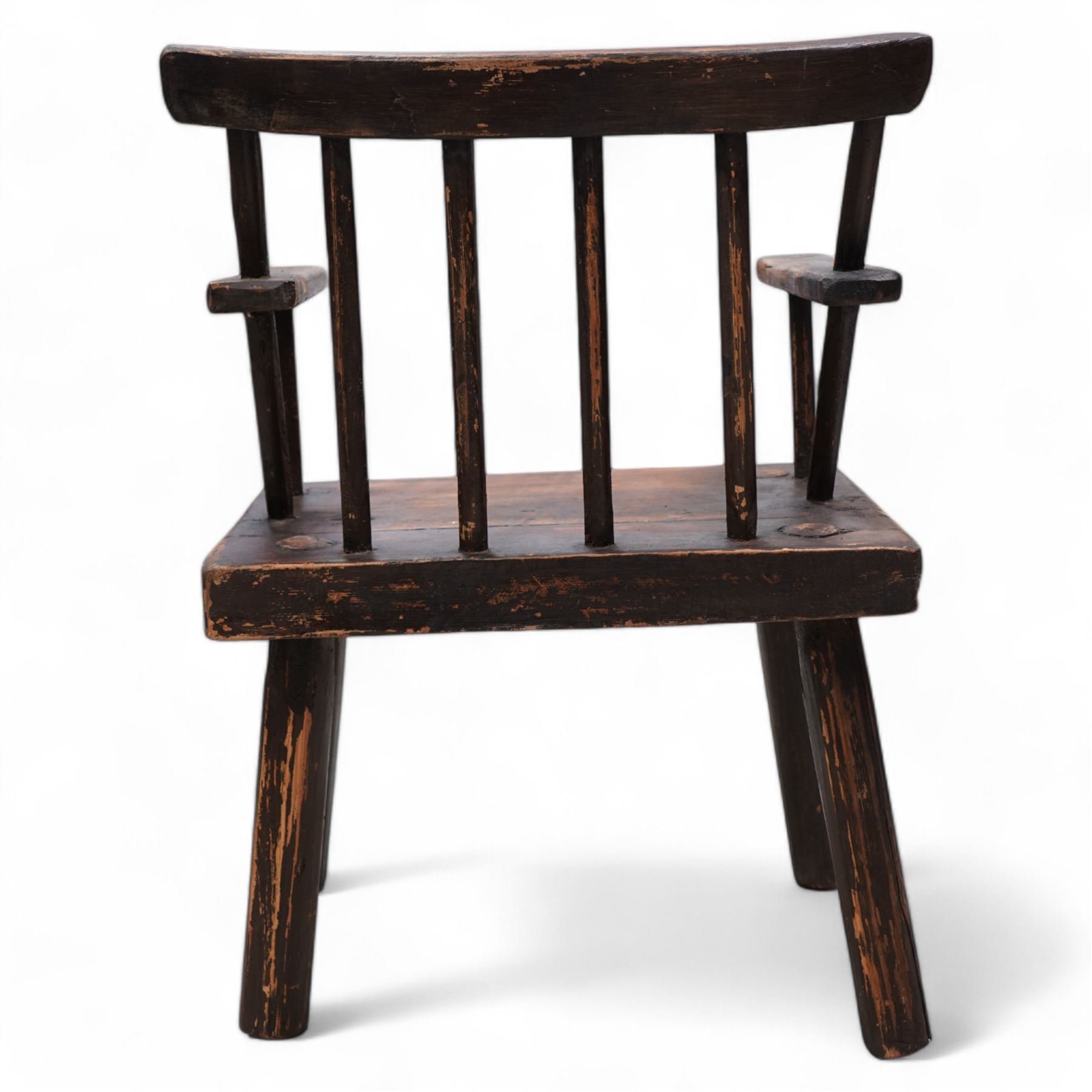 Vernacular 'Irish famine' or 'primitive' pine chair, bar cresting rail over spindle back, flat arms on thick plank seat, rounded supports 