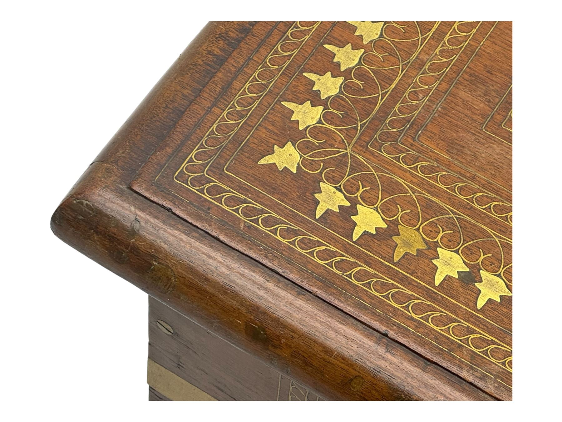 20th century mahogany chest, rectangular hinged top enclosing removable compartments with carved starburst motifs with linear and geometric patterns, brass inlay to the top and front, mounted corners and edges, on bracket base