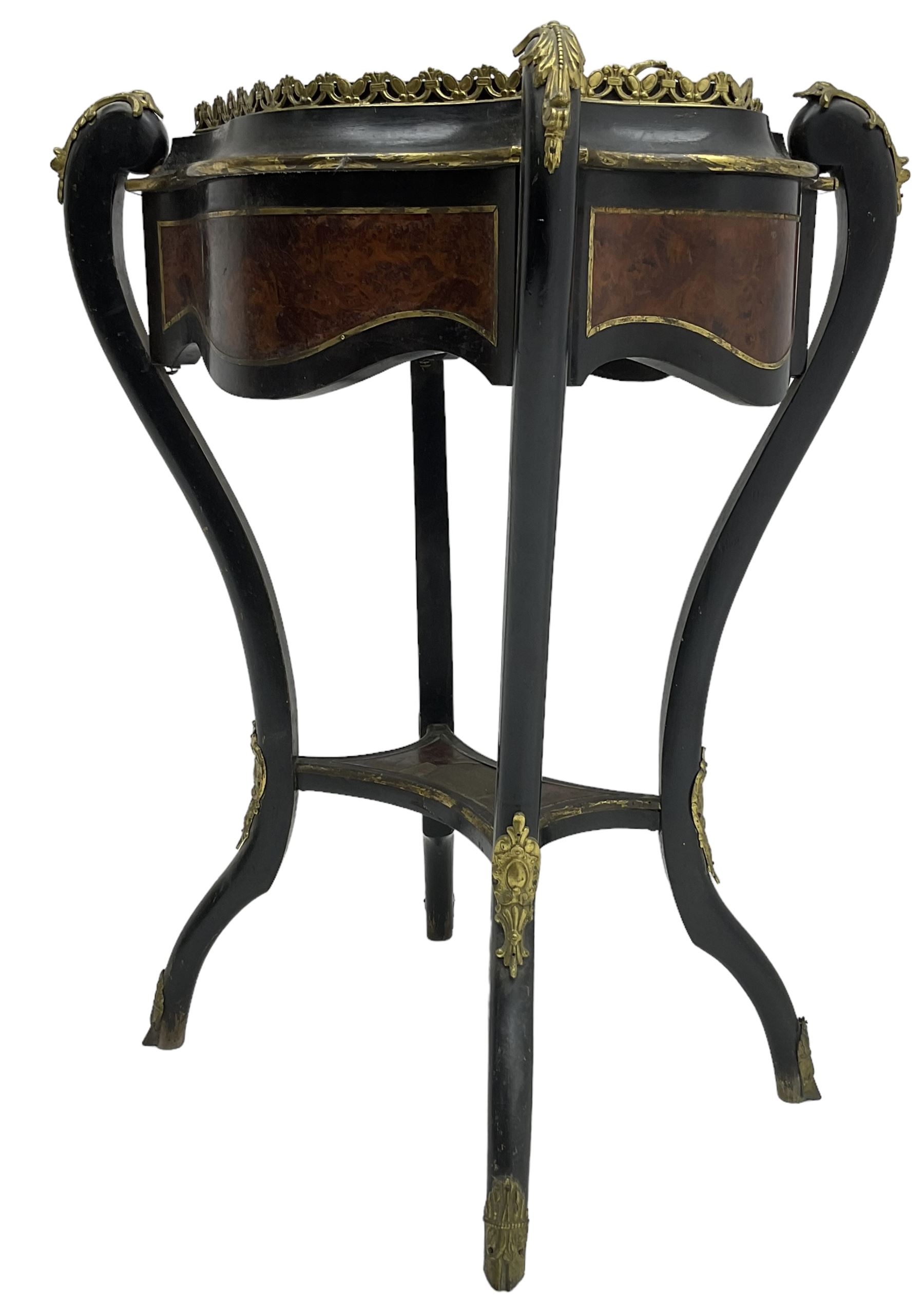 Late Victorian ebonised and amboyna wood jardinière planter, shaped form with removable lid inlaid with scrolling brass work and mounted by ornate cast gilt metal handles, the frieze rails inlaid with amboyna panels and brass stringing, on cabriole supports united by under-tier, decorated with cast gilt metal acanthus leaves and hooved feet caps