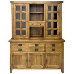 Oak dresser, upper section with twin glazed cupboard doors and central shelving with two trinket drawers, lower section fitted with six drawers over three panelled cupboard doors, raised on shaped feet 