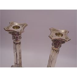 Pair of modern silver Corinthian column candlesticks, each with removable sconces with dart edging and embossed detailing, with personal engraving in a Semitic language, upon weighted stepped square bases, hallmarked Birmingham 1962, maker's marks HYC, H30.5cm