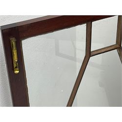 Early 20th century mahogany bookcase, projecting dentil cornice over blind fretwork frieze, enclosed by two astragal glazed doors, on shaped bracket feet 