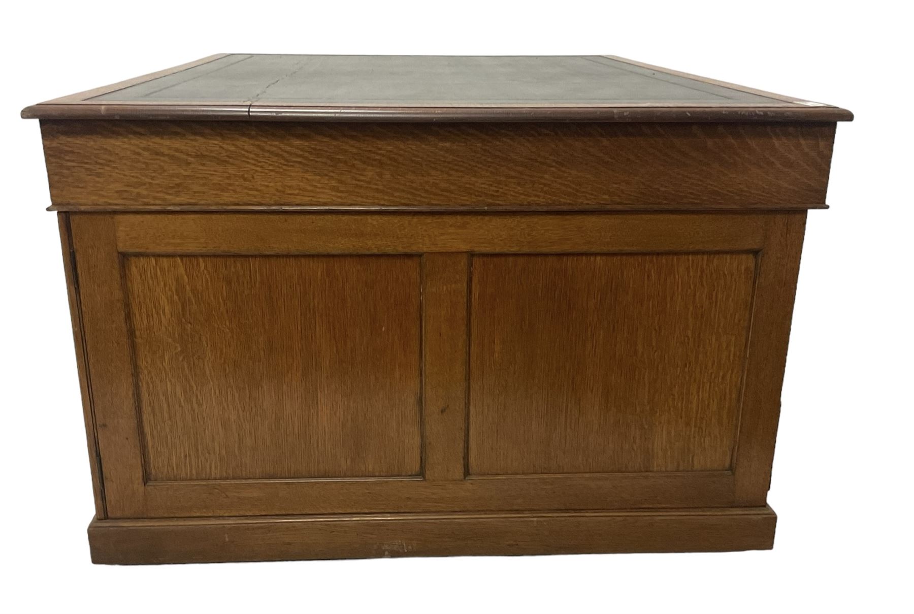 Late 19th century twin pedestal oak partner's desk, rectangular top with inset green leather writing surface, fitted with nine graduating drawers to each side, the rear drawers enclosed by panelled cupboards