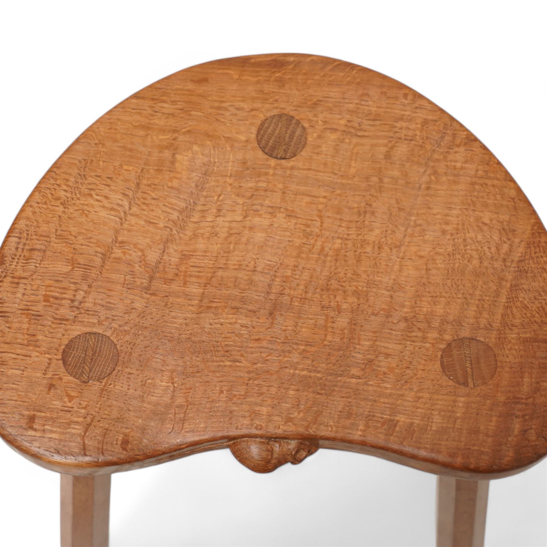 Mouseman - oak three-legged stool, dished kidney-shaped seat on three octagonal splayed supports, carved with mouse signature, by the workshop of Robert Thompson, Kilburn