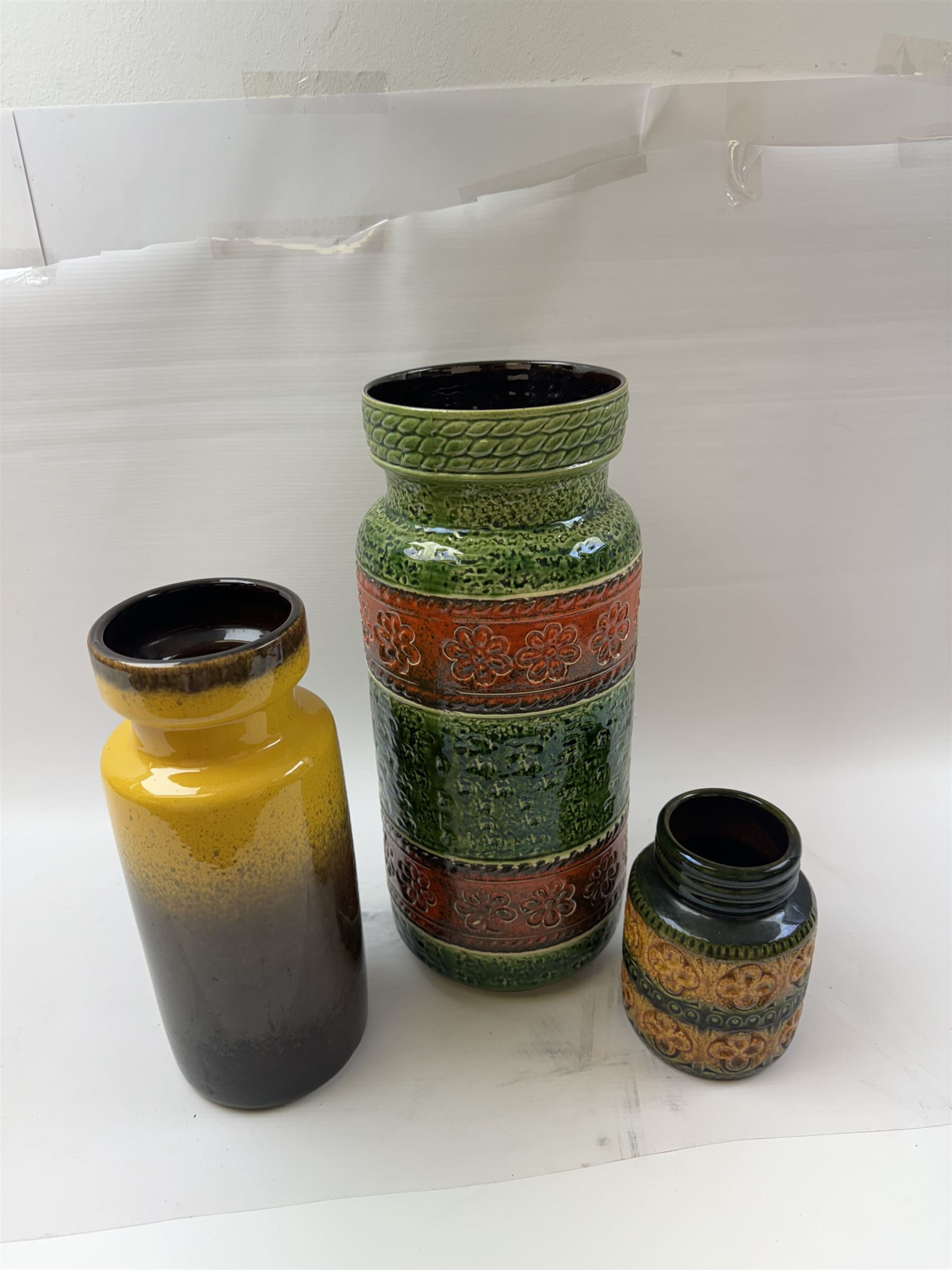 Three West German vases, to include orange and green example with floral decoration and a similar smaller example, tallest H40cm