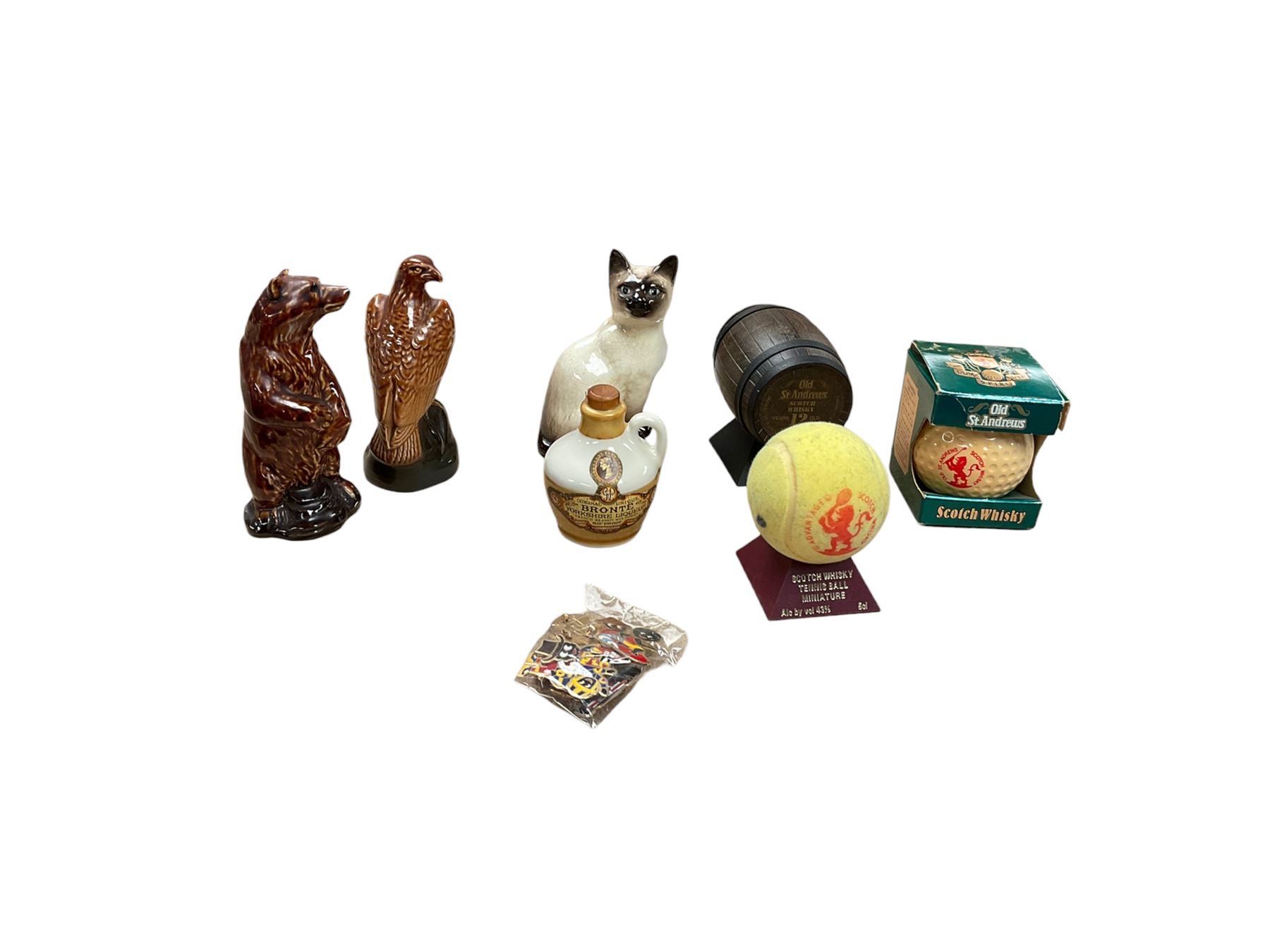 Six whisky miniatures in novelty decanters, together with Beswick cat, and nine Robertsons Golly badges