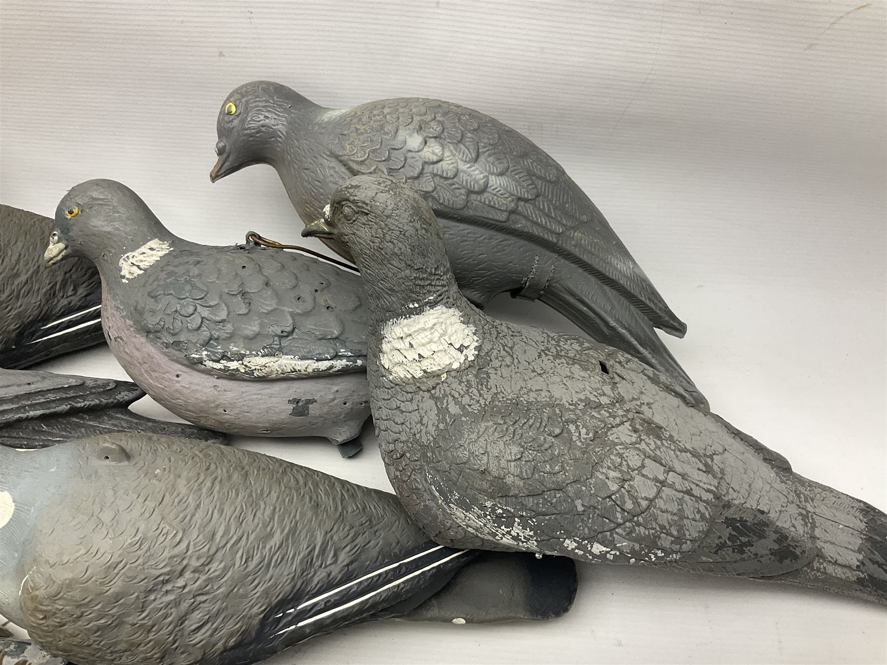 Fourteen Wood Pigeon decoys, together with camouflage netting