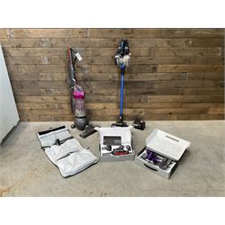 Dyson DC40 vacuum cleaner with various attachments, and a Vax cordless vacuum cleaner with single battery and charger