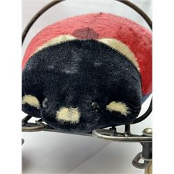 Steiff child's ride on ladybird, circa 1950s, the mohair body with red and black spotted seat, black and white face and blue underbelly, upon a metal frame with rubber and metal wheels, H30cm, W52cm