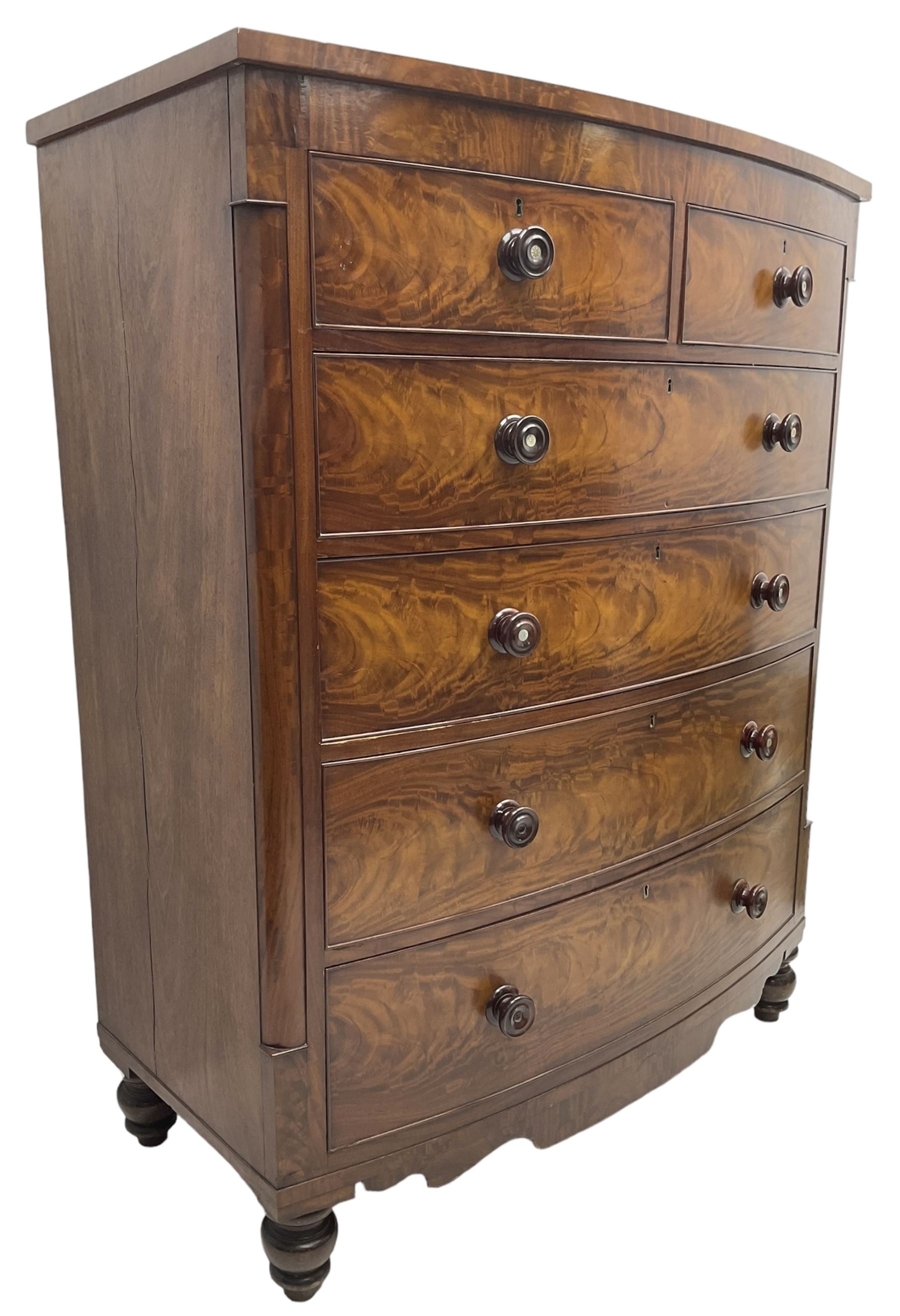 Tall Victorian mahogany bow-front chest, fitted with two short over four long cock-beaded drawers, with turned handles, canted upright corners with quarter columns, shaped apron, on turned feet