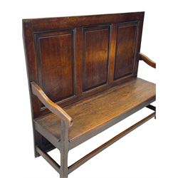 18th century oak settle, the high back with three fielded panels, shaped arms and solid plank seat, standing on square supports joined by stretchers