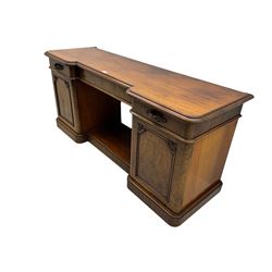 Mid-19th century figured mahogany sideboard, moulded reverse-break front, fitted with three drawers and two cupboards, carved faux bois handles, enclosed by panelled doors with book-matched veneers, applied geometric mouldings and scroll leaf decoration, on moulded plinth base 