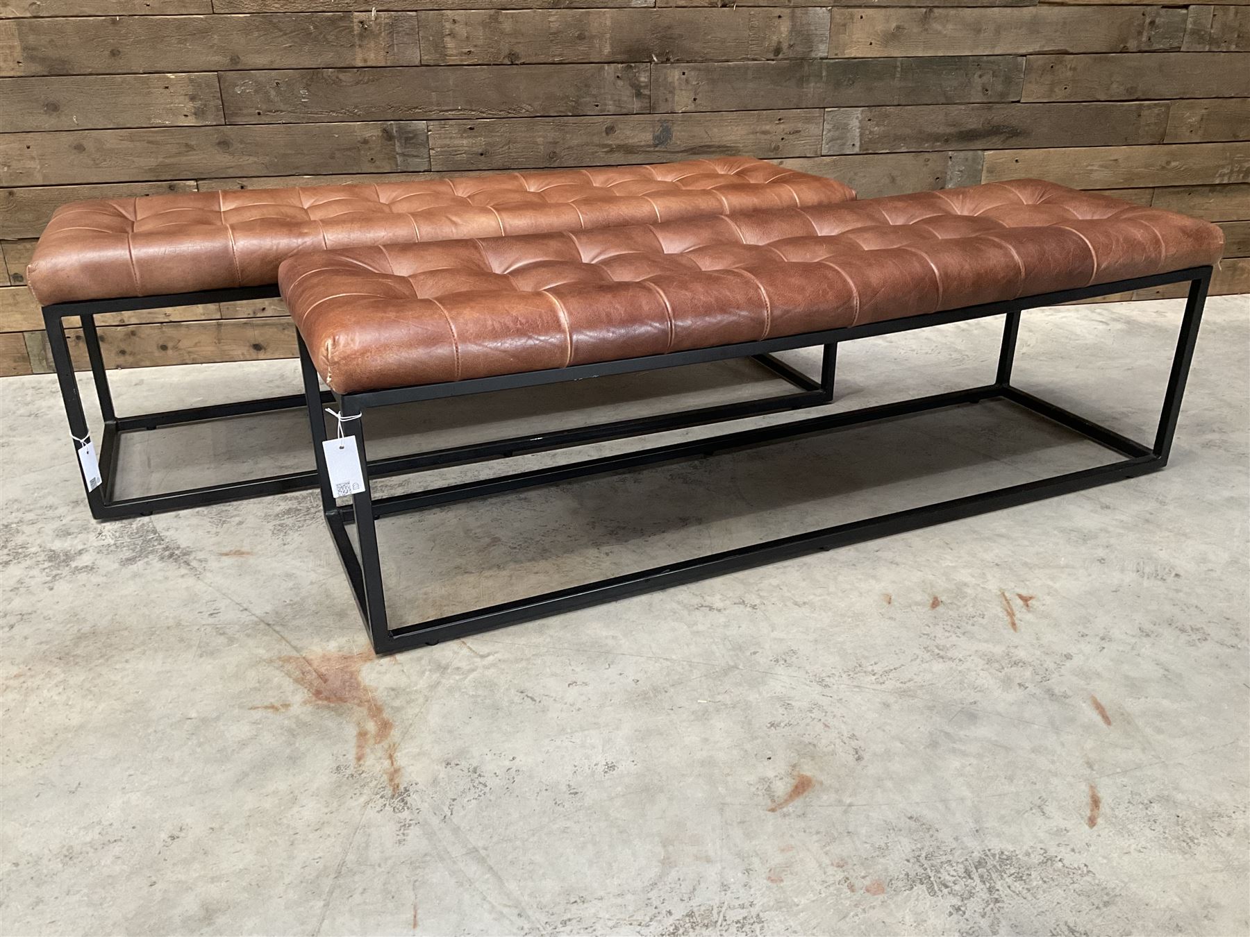 Two rectangular metal framed benches, upholstered in buttoned tan leather