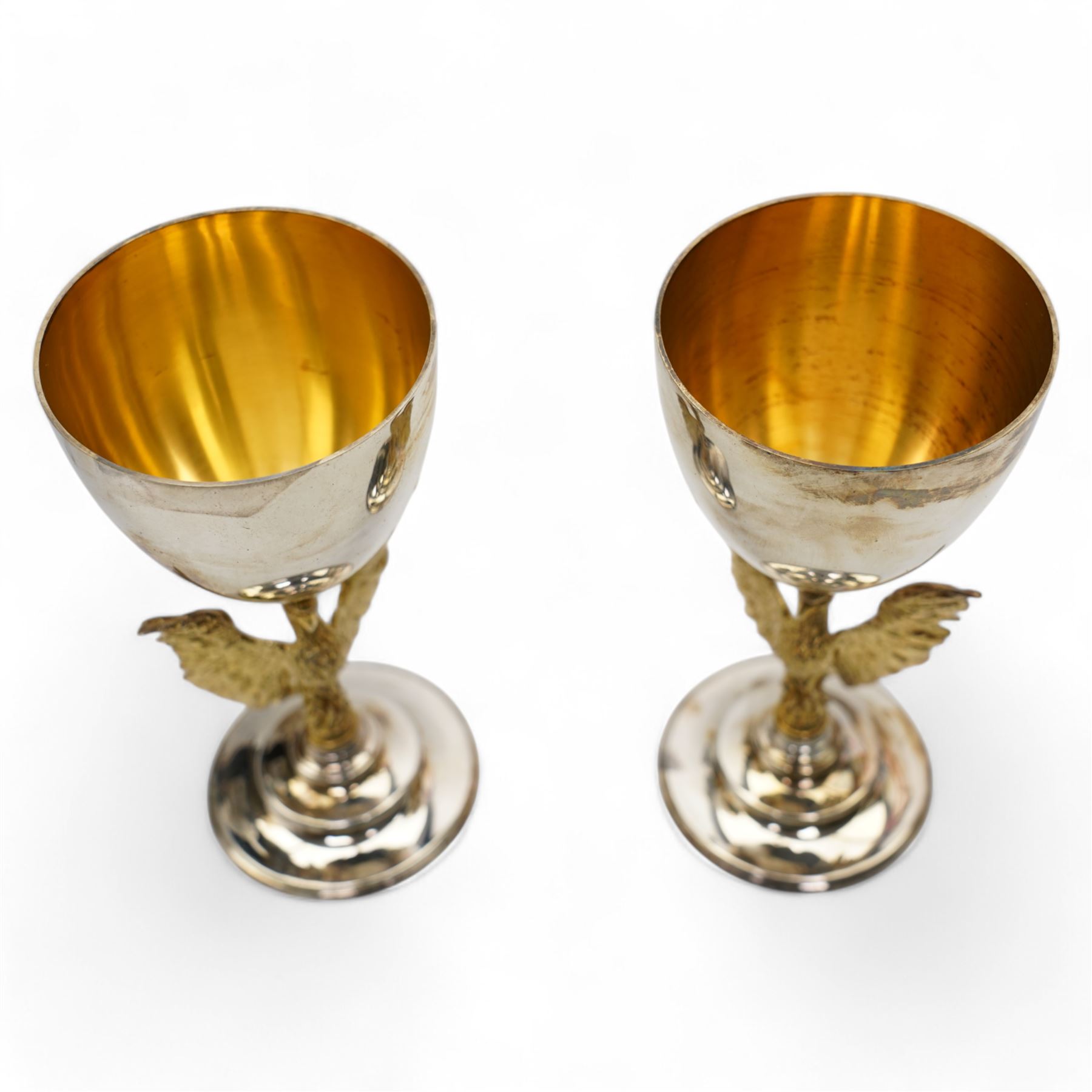 St Paul's Cathedral limited edition silver goblets, commemorating the 300th anniversary of the laying of the foundation stone of the cathedral in 1675, designed by Jocelyn Burton for Aurum, the gilt stems sculpted as phoenixes with outstretched wings supporting the bowl, the pedestals inscribed 'Resurgam', with gilded interiors, no. 188 and 189/600, hallmarked Jocelyn Burton, London 1975, H16cm, with certificates and original case