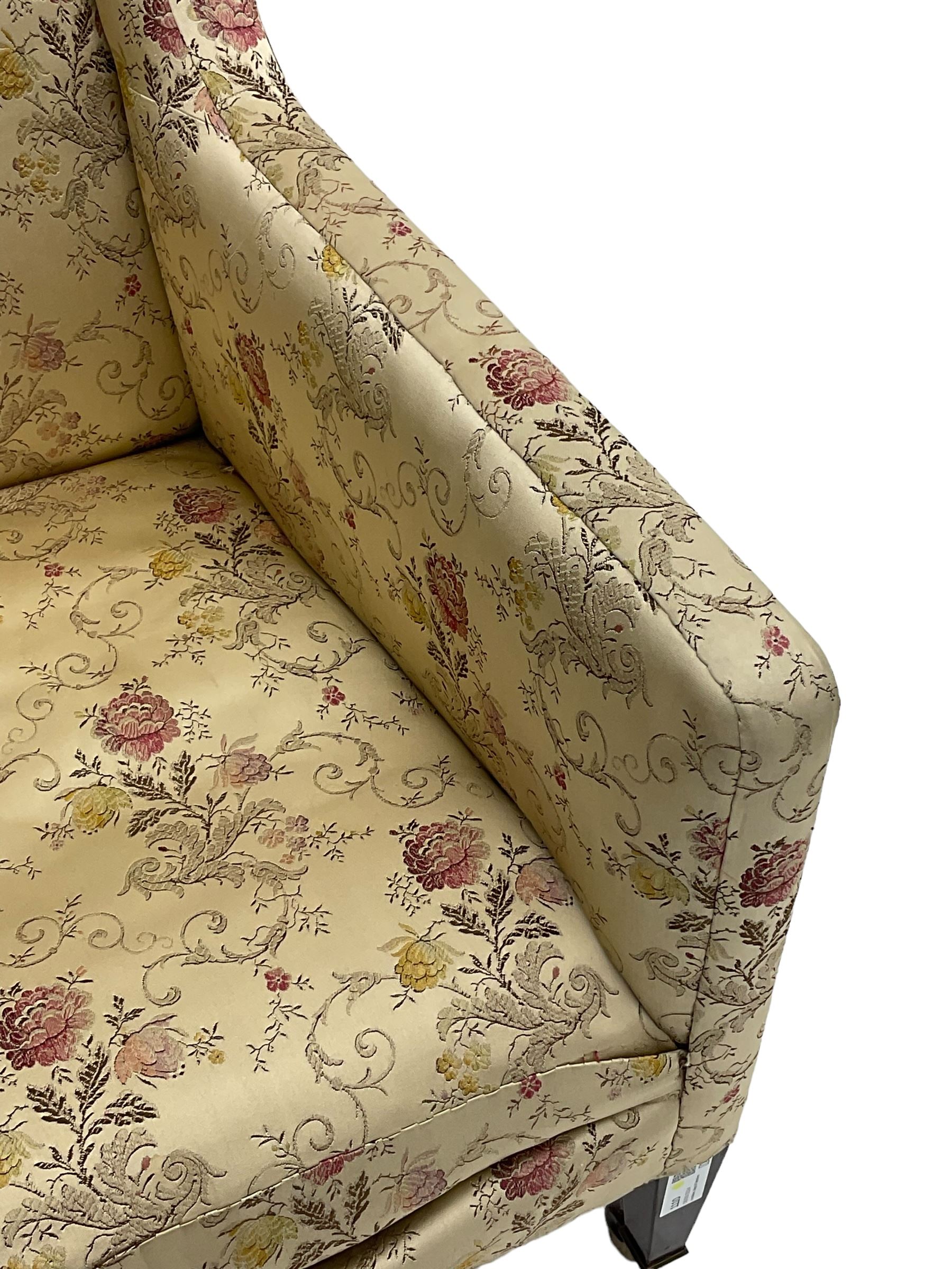 Edwardian hardwood-framed armchair, upholstered in floral pattern fabric, on square tapering front supports, brass and ceramic castors 