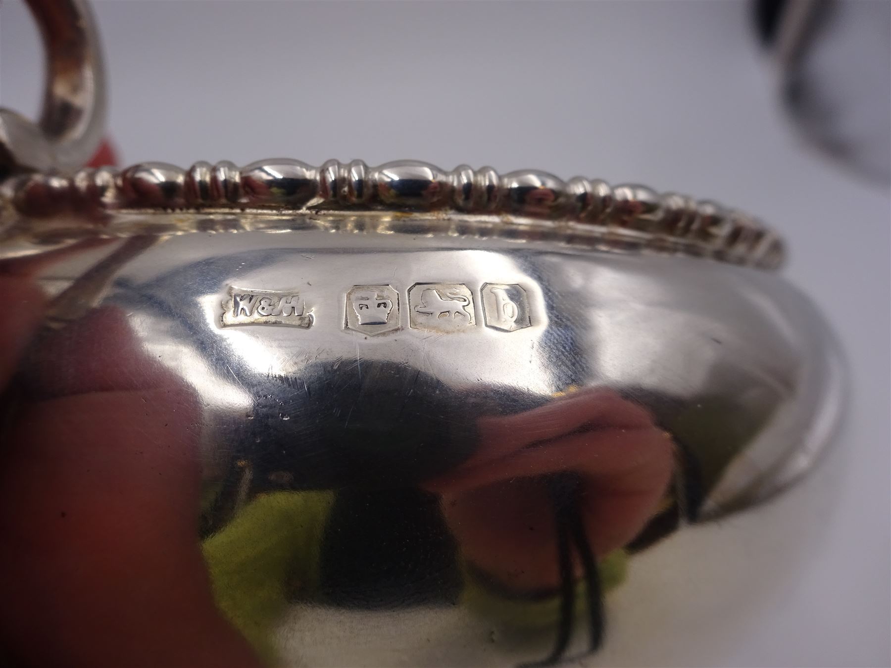 Early 20th century silver twin handled bowl, of plain bellied form with bead and dart rim and two C scroll handles, upon a circular foot, hallmarked Walker & Hall, Sheffield 1919, including handles H9.5cm