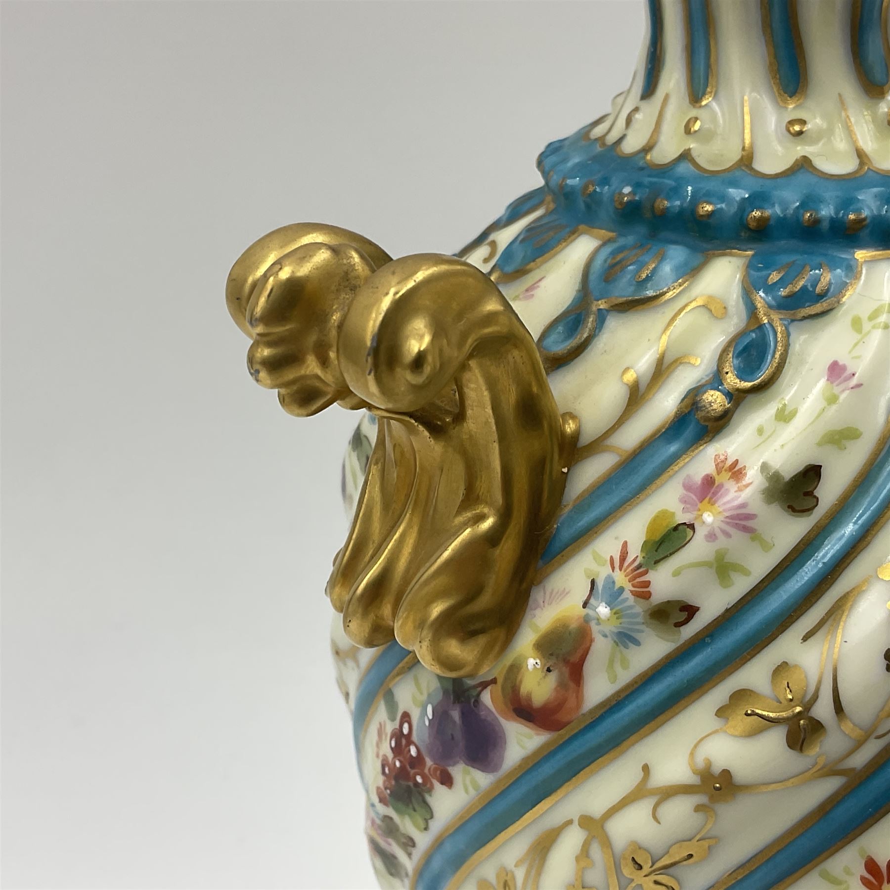 Pair of late 19th/early 20th century Sevres style vases and covers, of baluster form with gilt scroll handles and domed covers, the wrythen fluted bodies decorated with alternating bands of painted fruit and flowers and gilt vines, upon a white and celeste blue ground, with printed and impressed marks beneath, H22.5cm 